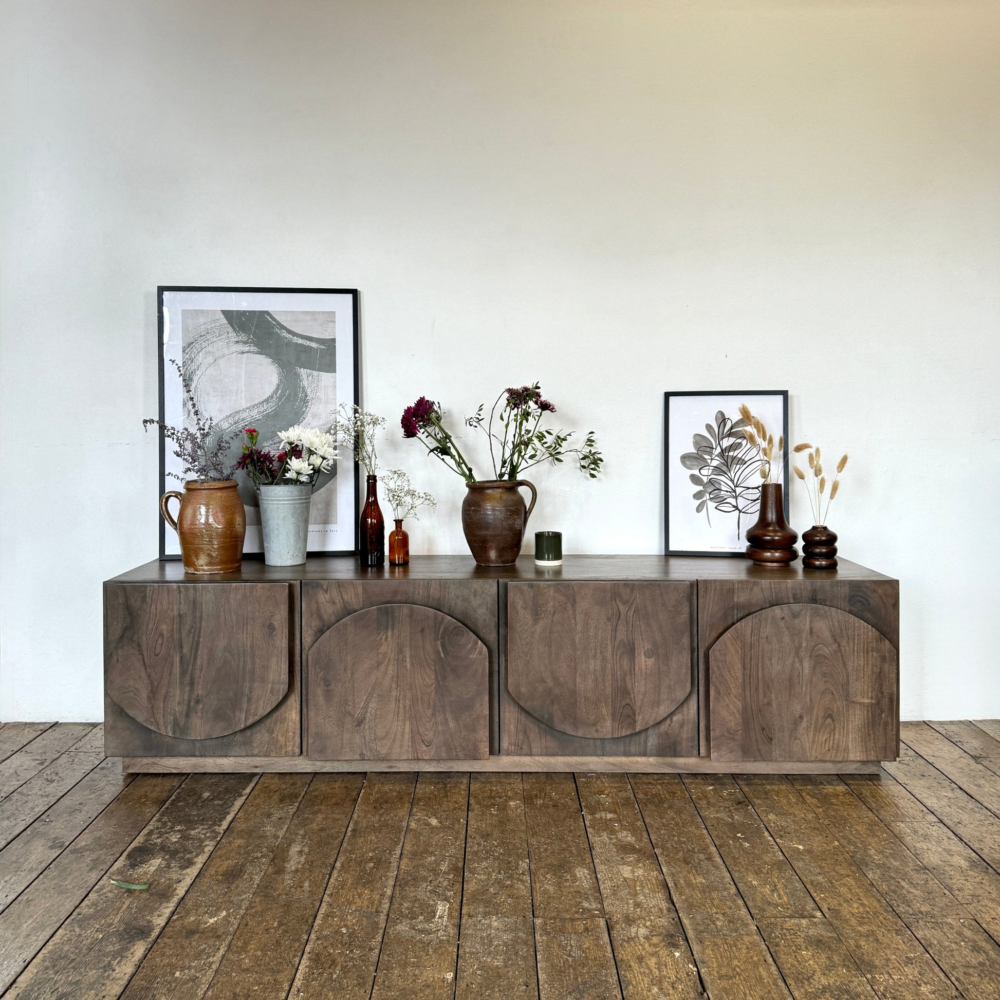Wooden sideboard with decorative items against a white wall
